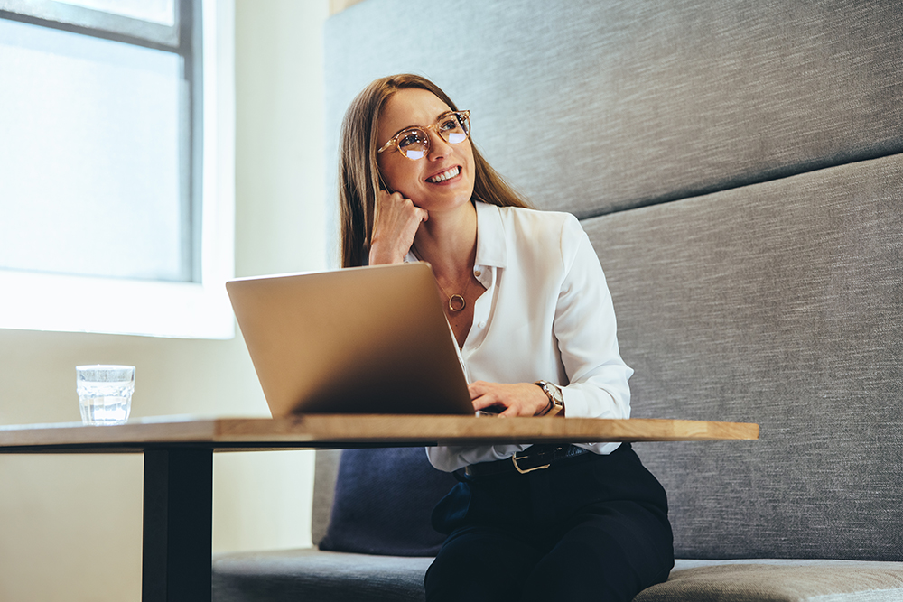 Young female entrepreneur working on a laptop in a modern workspace